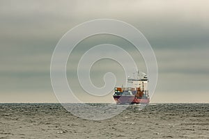 Red cargo container ship sailing