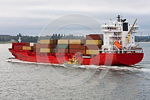 Red cargo container ship at sea.