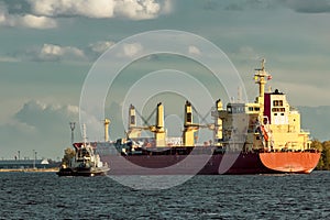 Red cargo ship and the tug ship