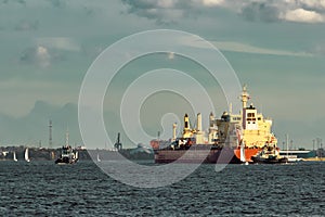 Red cargo ship and the tug ship