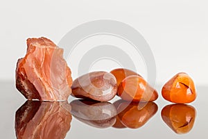 Red carnelian, uncut and tumble finished, reflections
