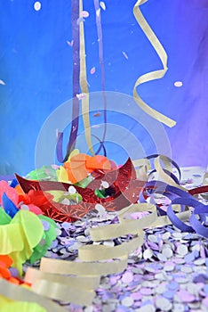 Red carnival costume mask in colorful confetti and streamers on pink background with space for text photo