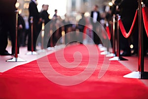 red carpet being rolled out along the entrance of premiere event, with paparazzi in the background