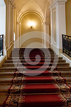 Red carpet on the staircase in luxury interior