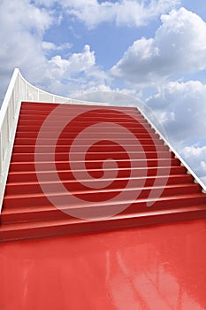 Red carpeted staircase in the clouds photo