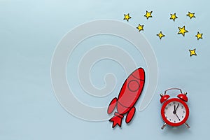 Red cartoon rocket with alarm clock and stars