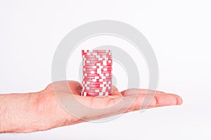 Red casino chips on human hands isolated on white