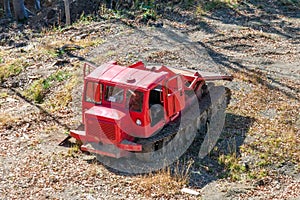 Red caterpillar tractor tractor in the forest on clearing the trail for road construction