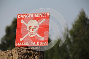 Red caution sign in a minefield in the Republic of Congo