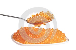 Red caviar in the ceramic plate and silver spoon isolated on a white background. Trout or salmon caviar close up. Macro shot