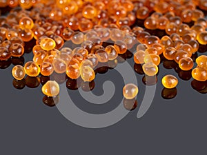 Red caviar on a dark background with a reflection. Gourmet food, seafood. Close up. Copy space