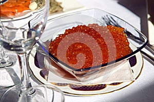 Red caviar in a glass plate on the holiday