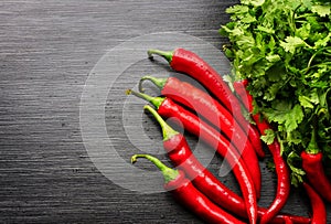 Red cayenne peppers Capsicum annuum and verdure on wooden table. Top view.