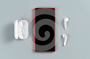 Red Cell phone and white wireless earphones