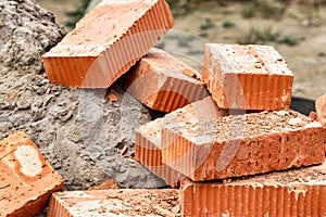 Red ceramic bricks at the construction site. Keramoblock. Hollow brick. Construction of a red brick building. Close-up. Material