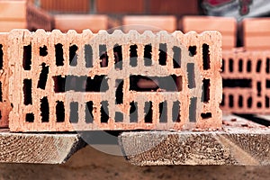 Red ceramic bricks at the construction site. Keramoblock. Hollow brick. Construction of a red brick building. Close-up. Material