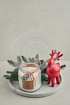 Red  ceramic deer and candle in jar with fir tree branches