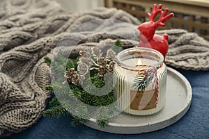 Red ceramic deer and candle in jar with fir tree branches