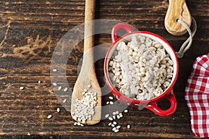 The red ceramic saucepan with white polka dots complete crumbly barley porridge