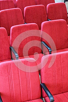 Red chair close-up.  Rows seats in empty movie theater.