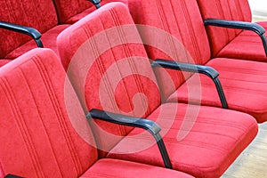 Red chair close-up.  Rows seats in empty movie theater.