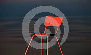 Red chair on a lagoon background. Lithuania, Nida