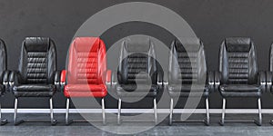 Red chair in a row of black chairs in an office. Business, leadership, recruiting and employment concept