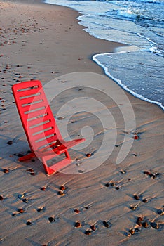 Red chair on the shore