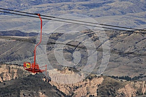 Red Chairlift with brown mountain range in distance