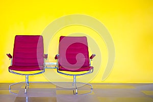 Red chairs against yellow wall.