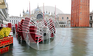 Red chairs of the alfresco cafe in Saint Mark Square  flooded du photo