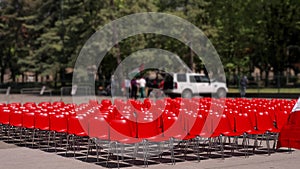 Red Chairs Arranged for Outdoor Event in Park Setting, Preparation Scene