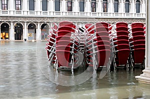 red chairs of a restaurant in Venice Italy with high water