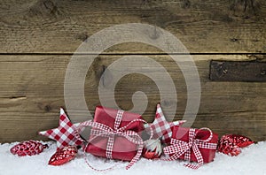 Red checked christmas presents on wooden country style background.