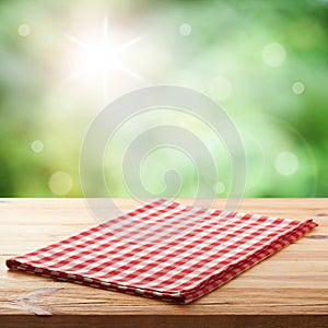 Red checked tablecloth on wooden deck table.