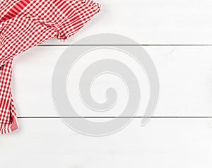 Red checkered dishcloth on white wooden plank table flat lay top view from above