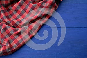 Red checkered fabric on a blue wooden background