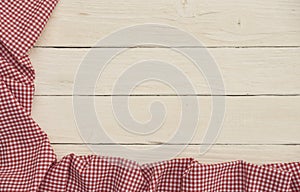 Red checkered fabric on white wooden background