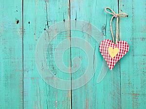 Red checkered and gold hearts handing on antique green wood door