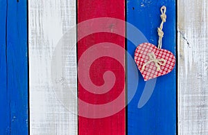 Red checkered heart hanging on old weathered door