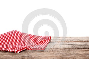 Red checkered napkins on wooden table against white background