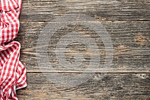 Red checkered picnic textile on rustic wooden planks background