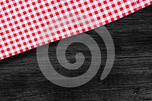 Red checkered table cloth on dark wooden table.