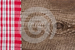 Red checkered tablecloth on the old wooden table with copy space for your text. Top view