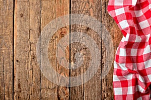 Red checkered tablecloth right frame on vintage wooden table background - view from above