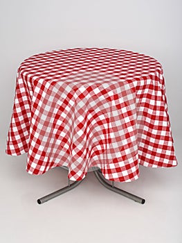 Red checkered tablecloth spread out on a round table on a white background