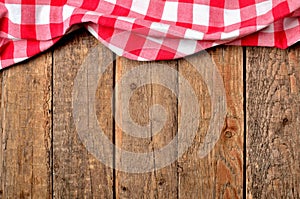 Red checkered tablecloth top frame on vintage wooden table background - view from above