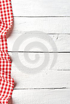 Red checkered tablecloth on white old wooden table with copyspace