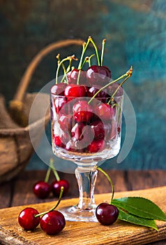 red cherries in a glass jar, on a wooden table, country atmosphere, ia generated