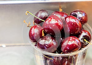 Red cherries in plastic cup in Mercado de la Boqueria.